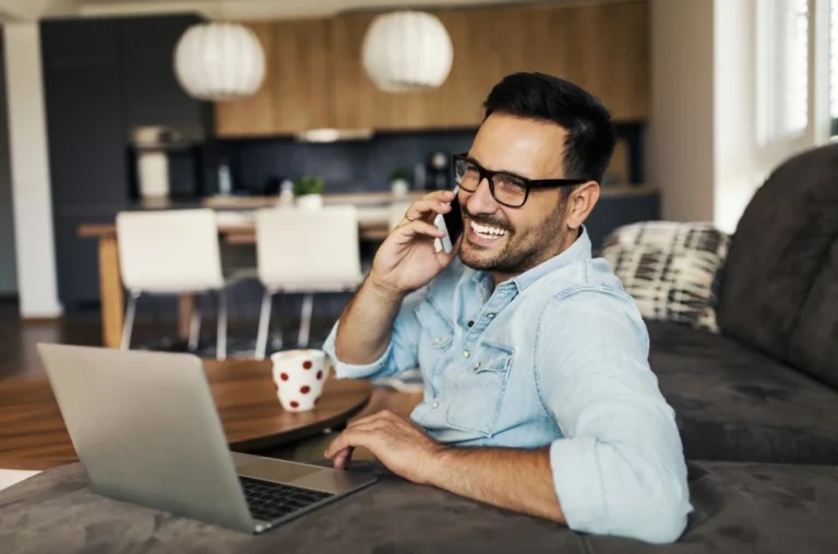 Portrait d'un freelance au téléphone et sur un ordinateur
